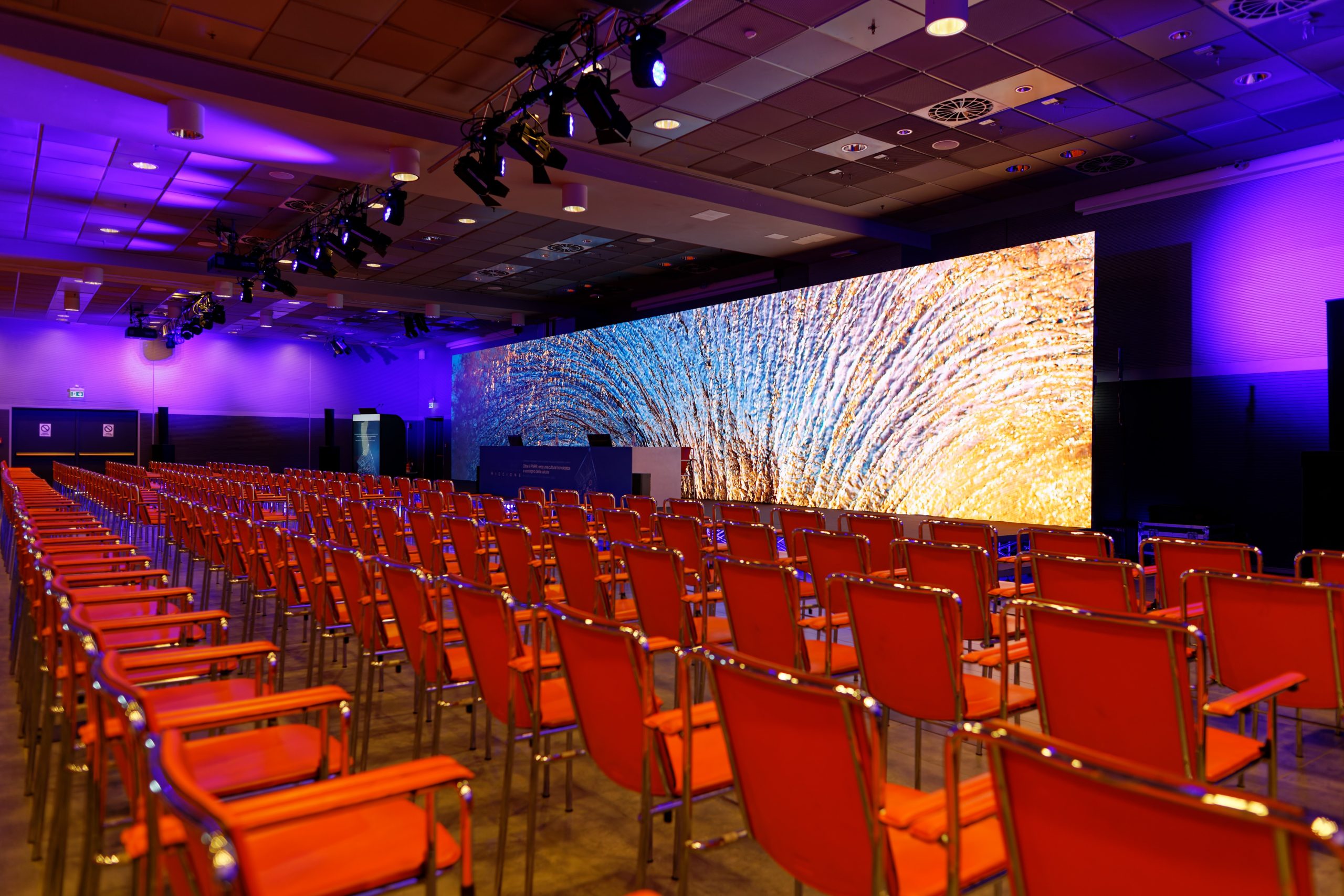 Sala con sedie e un LED wall sul palco