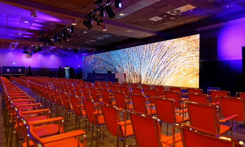 Sala con sedie e un LED wall sul palco