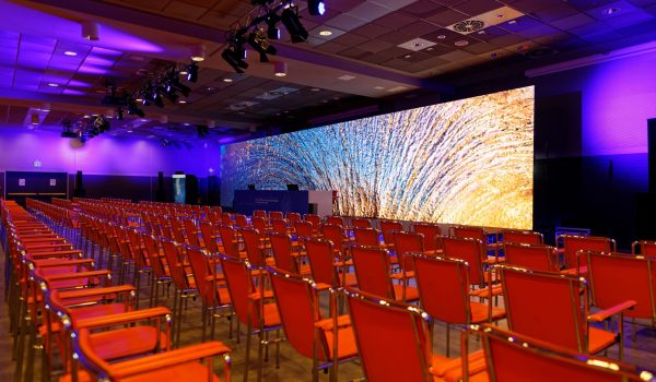 Sala con sedie e un LED wall sul palco